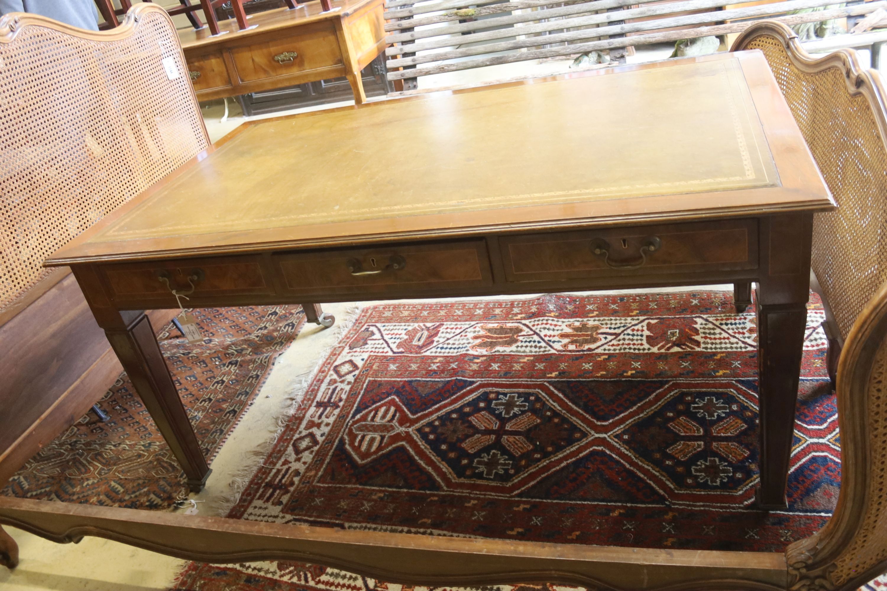 A mahogany two drawer writing table, with a green leather inset top, width 150cm, depth 90cm, height 75cm